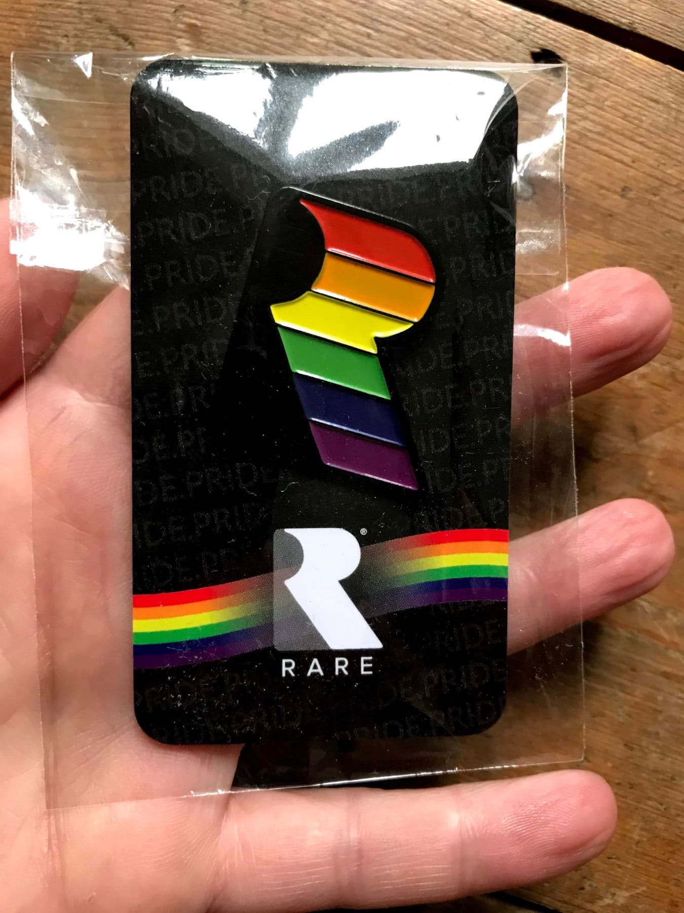 Rainbow Pride enamel pin on a backing card