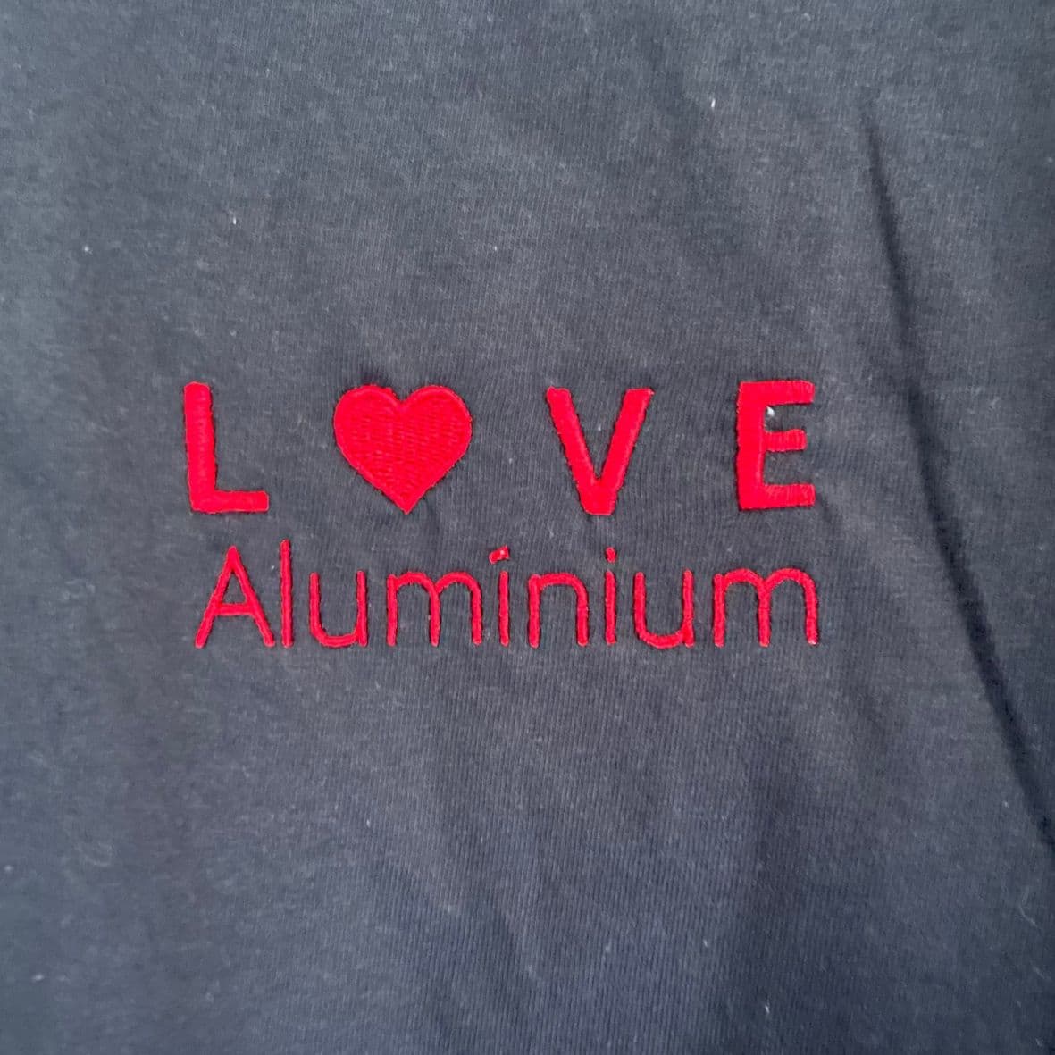 Love Aluminium logo embroidered in red on a navy garment